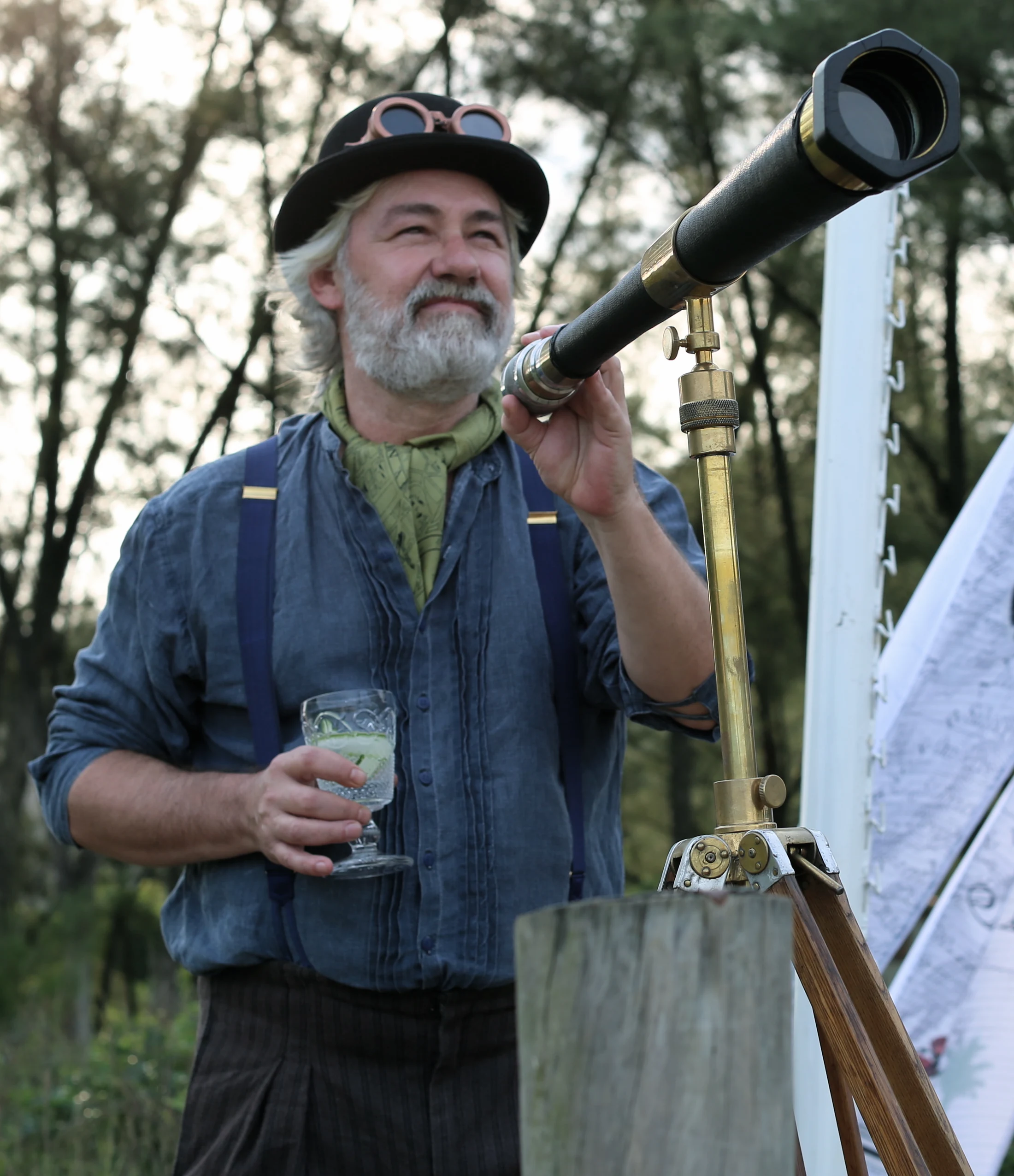 Personagem com figurino de época segurando uma luneta na ambientação do evento Hendrick’s.