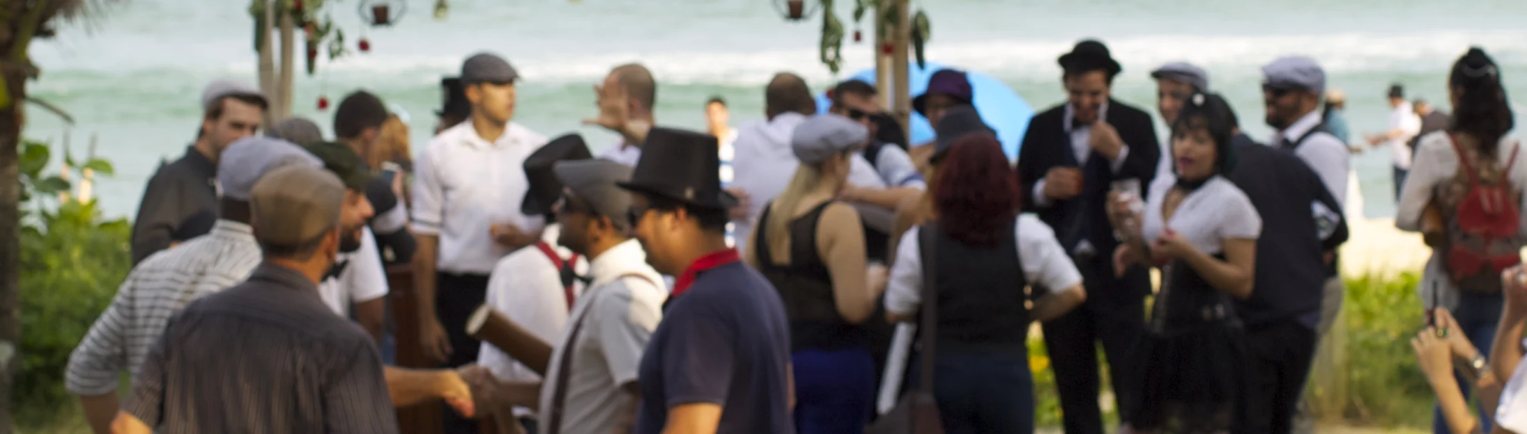 Convidados reunidos na praia, com figurinos e elementos da ambientação Hendrick’s.
