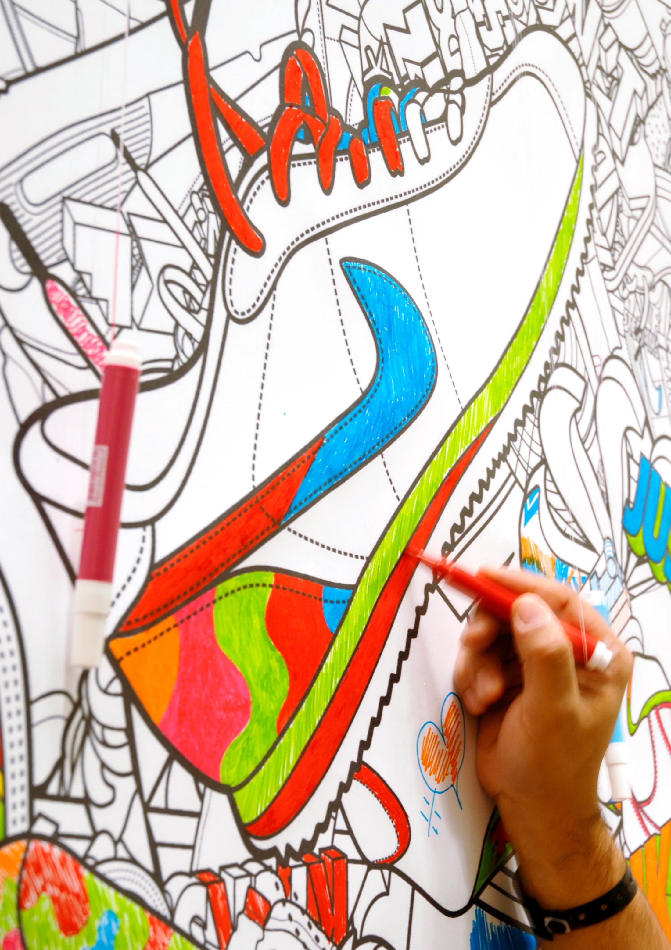 Detalhe da ilustração Nike Holiday sendo colorida à mão com caneta vermelha.